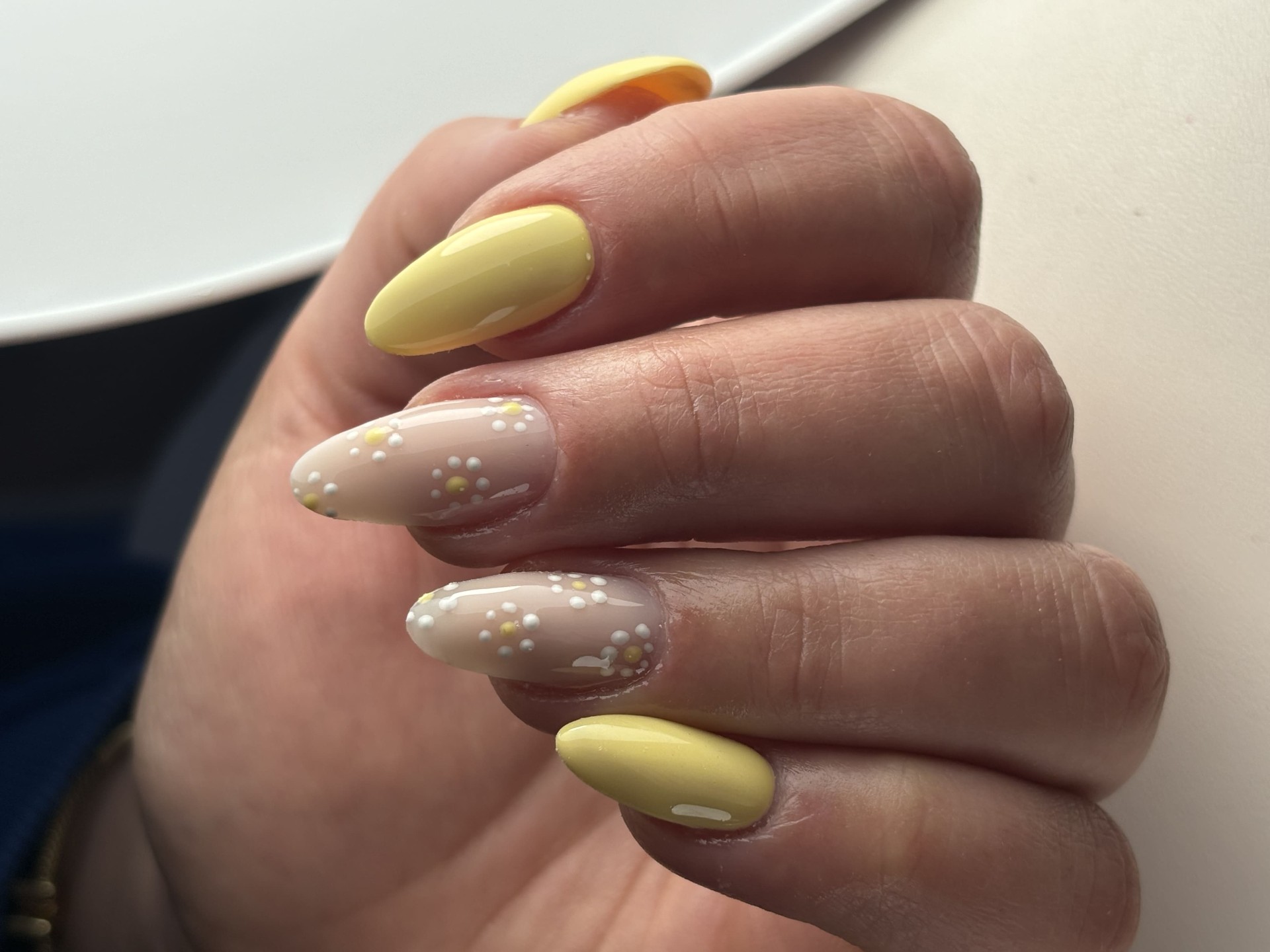 Pose jaune pastel avec nail art pointillé